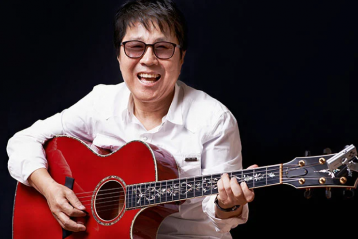 Korean rock musician with sunglasses holding a vibrant red acoustic guitar