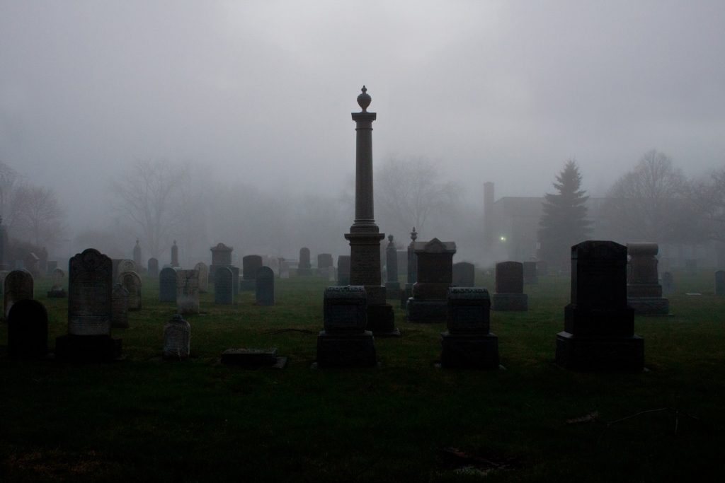 A foggy dark graveyard at night 