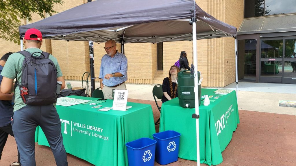 Two library workers tabling outside Wills Library. 