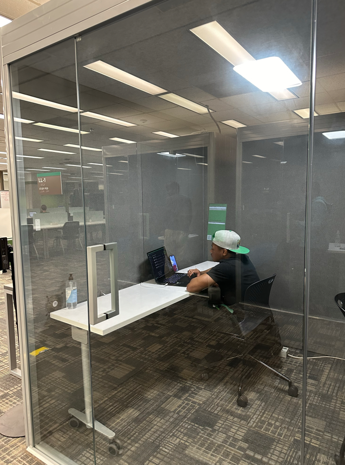 Patron using the study pod at lower level of Willis library