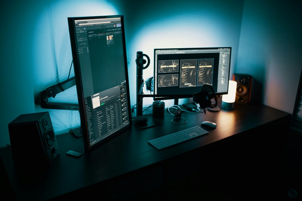 Two computer monitors in a dimly lit room. 