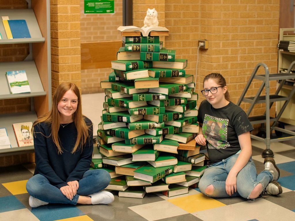 Student assistants relax after building the annual holiday book tree.