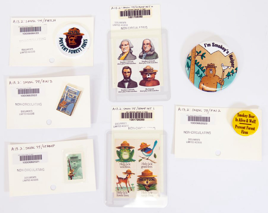 Smokey Bear stamps, pins, and badges