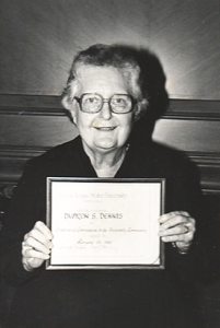 Portrait of librarian Damron S. Dennis holding up an award